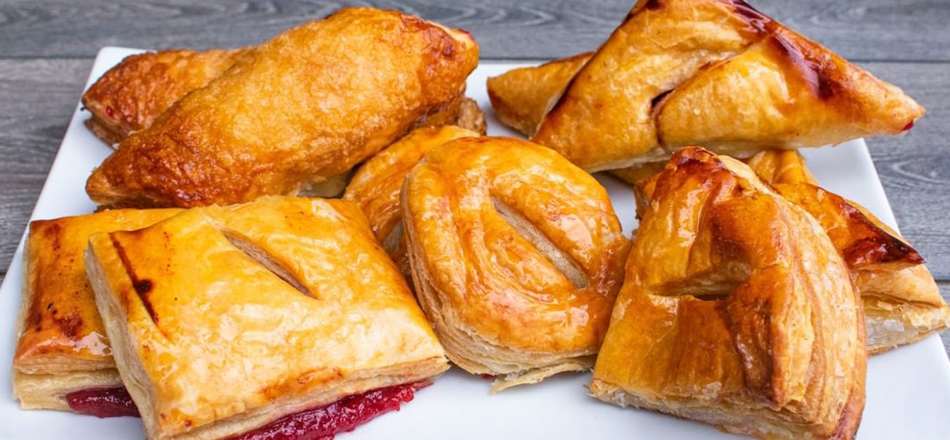 Vicky Bakery pastelitos arrangement on white plate, golden flaky pastries.